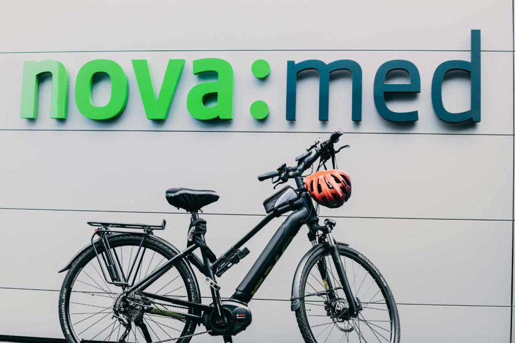 Fahrrad mit dem nova:med Logo im Hintergrund