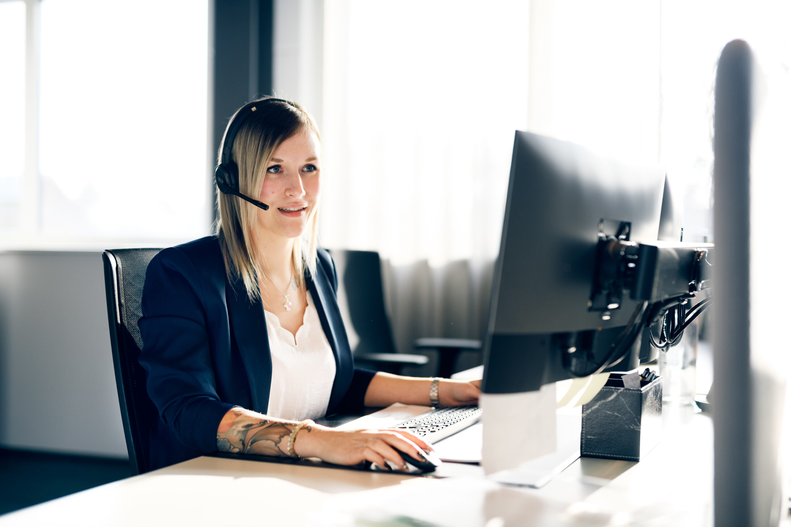 Kundensupport-Mitarbeiterin von nova:med am Arbeitsplatz mit Headset